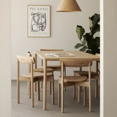 Sedia da pranzo Risu e tavolo Air in rovere di Ethnicraft in sala da pranzo moderna con poster Picasso.