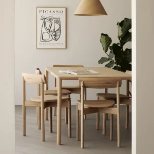 Sedia da pranzo Risu e tavolo Air in rovere di Ethnicraft in sala da pranzo moderna con poster Picasso.